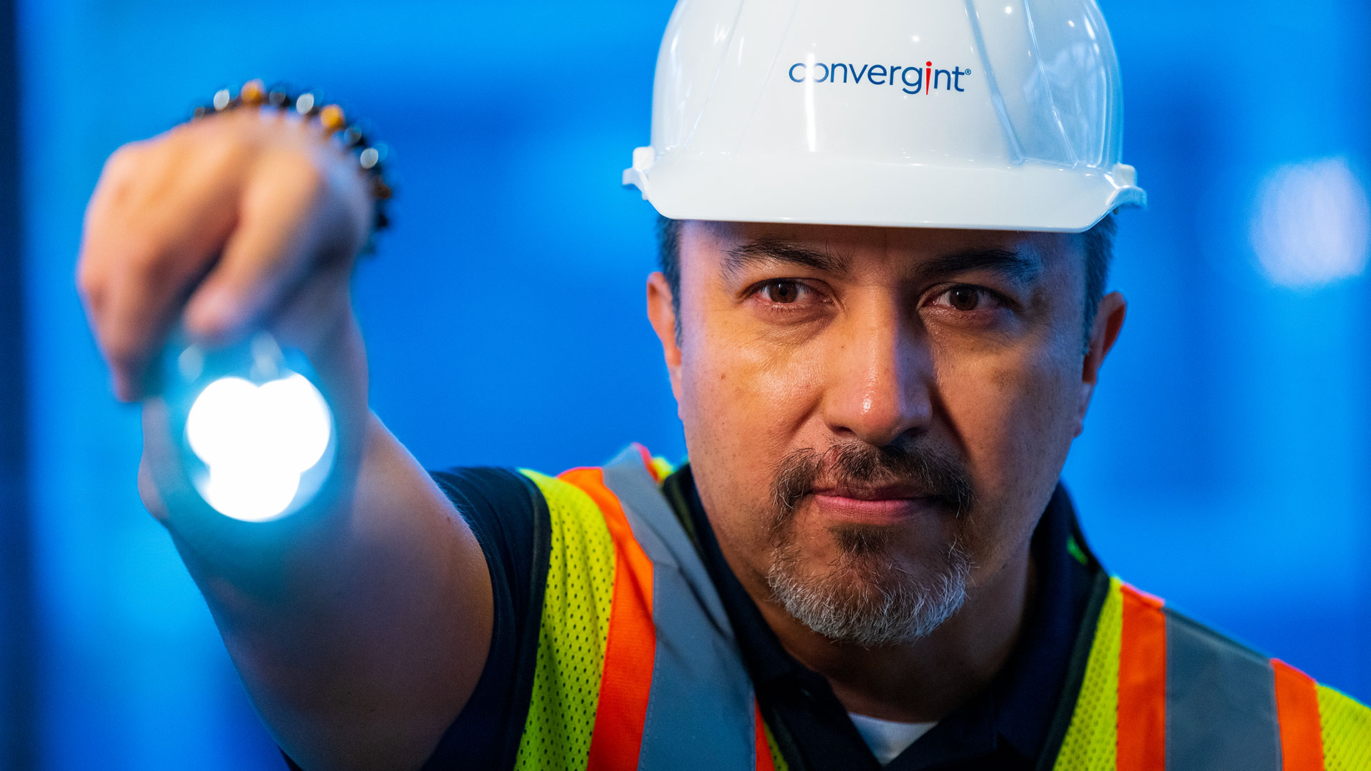 Convergint worker with hard hat and flashlight