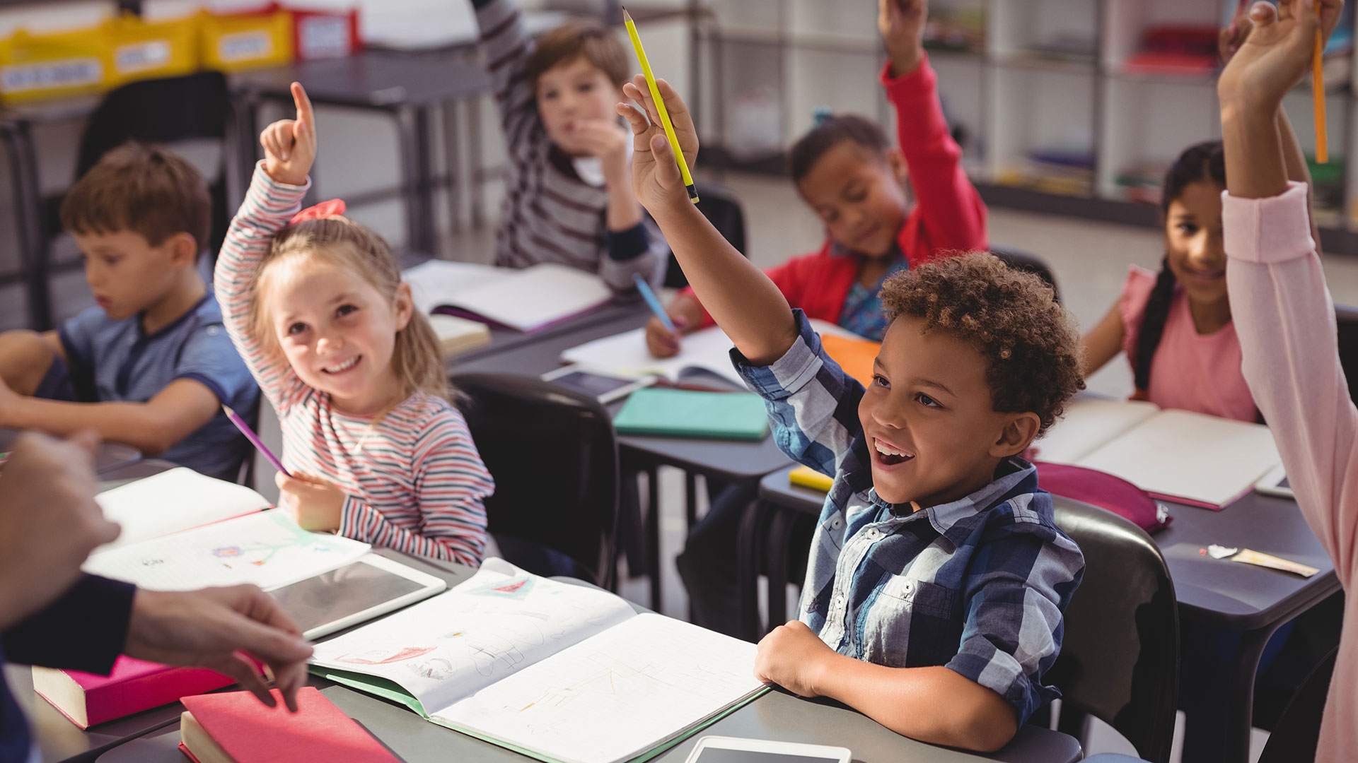 School kids raising their hands