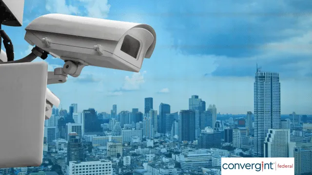 Closeup of a security camera with a cityscape in the background