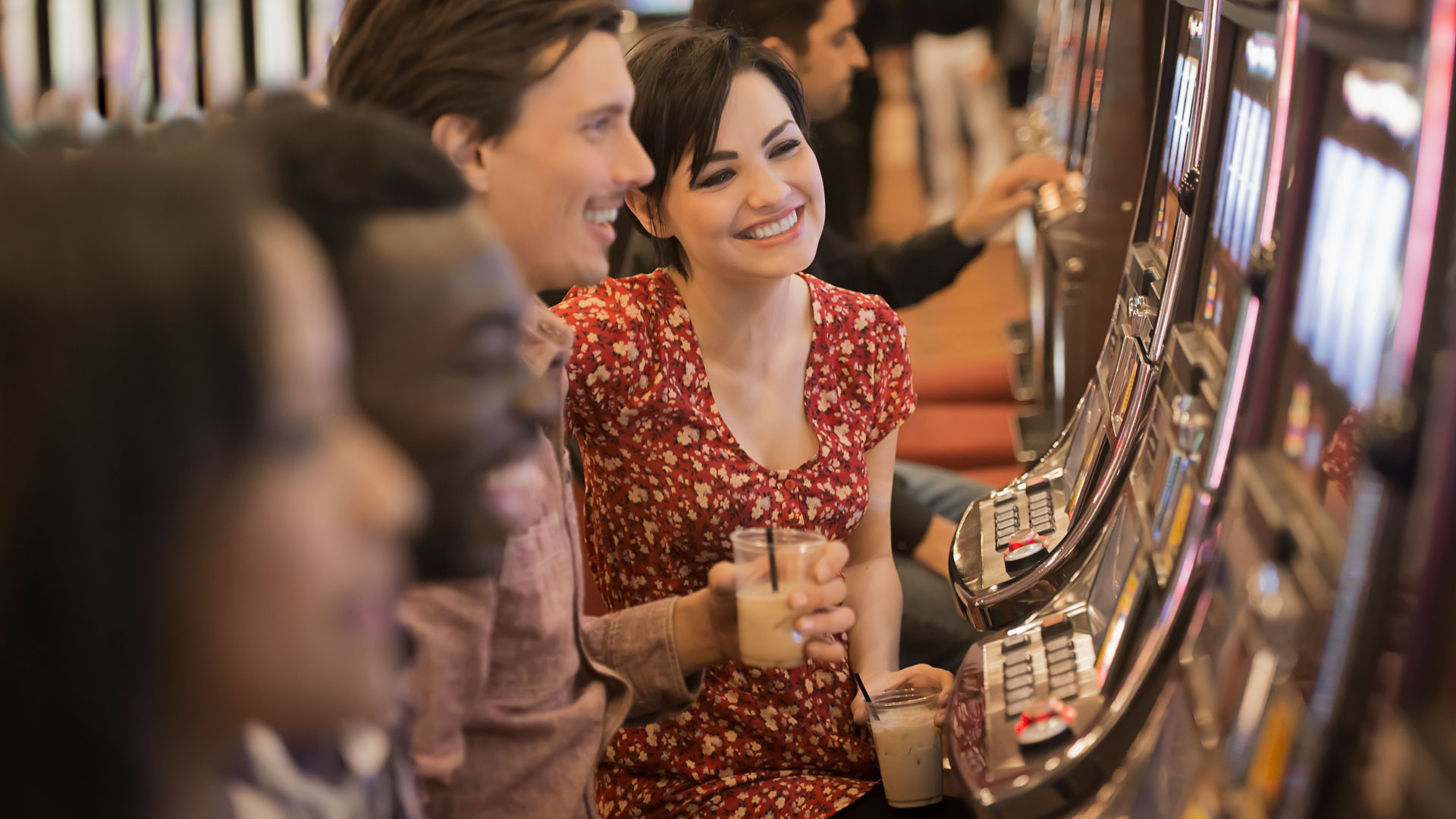 A group of people playing the slot machines in a casino.