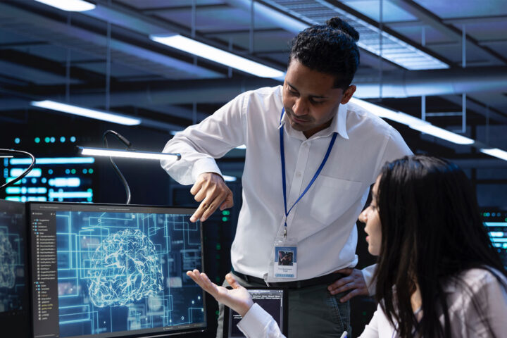 Teamworking colleagues in data center using PC to enable artificial intelligence