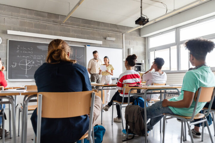 Teen hispanic girl high school student giving a presentation to multiracial classmates