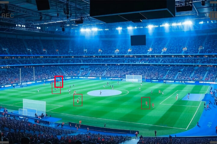 a security camera view of a soccer stadium filled with people with red squares tracking players across the field