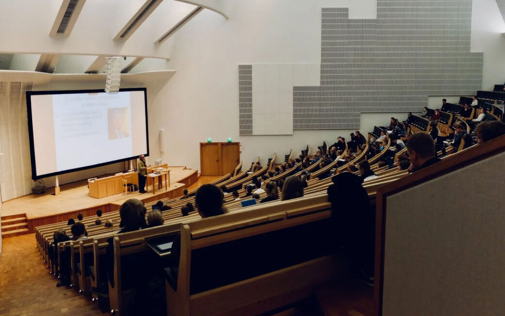 a college lecture hall with a professor speaking to his class